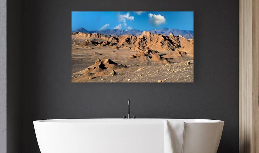 Rugged desert mountains under a clear blue sky with clouds. by Marco Brivio