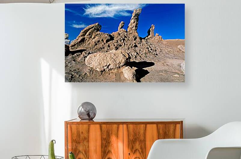 Dramatic desert rock formations under a vibrant blue sky. by Marco Brivio