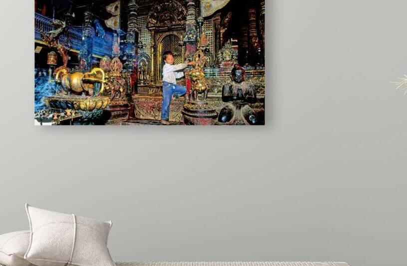 Boy interacts with religious artifacts in Kathmandu temple by Marco Brivio