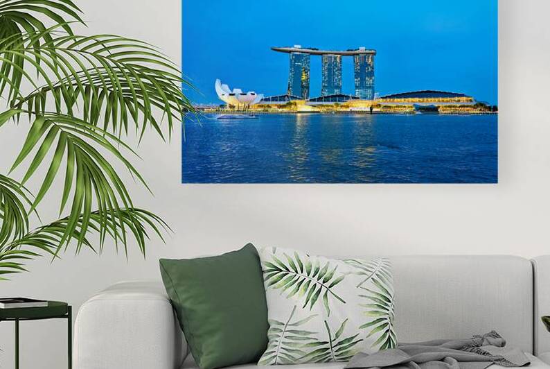 City skyline at sunset over Marina Bay with reflections on water by Marco Brivio