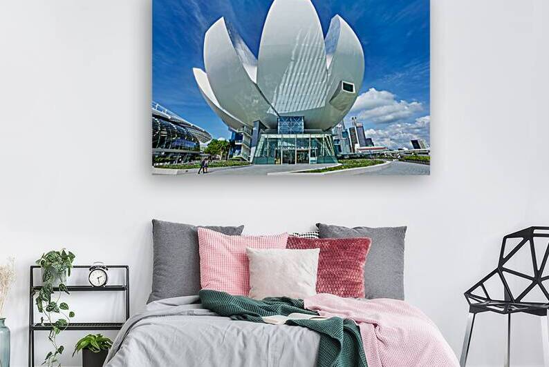Visitors look at ArtScience Museum with city skyline on a clear  by Marco Brivio