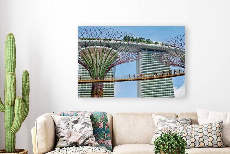 People walk on bridge connecting to Supertree Grove in Singapore by Marco Brivio
