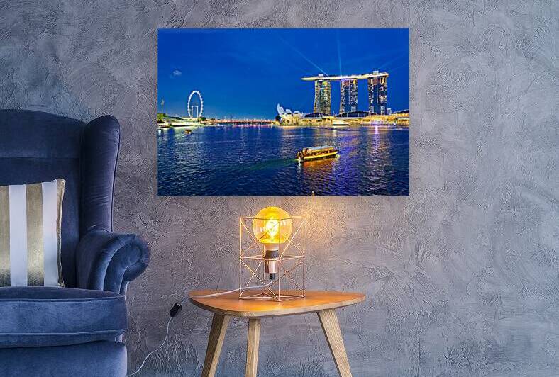 Skyline view of Marina Bay at sunset with people by the water by Marco Brivio