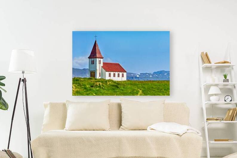 Church in Hellnar Iceland stands against blue sky and mountains by Marco Brivio