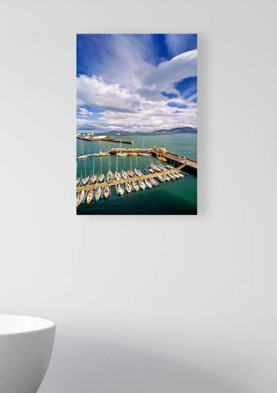 Sailboats docked in Reykjavik harbor under cloudy sky by Marco Brivio