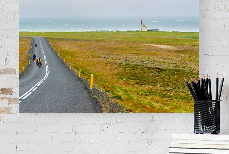 Cyclists riding near Kollafjardarnes Church in Iceland by Marco Brivio