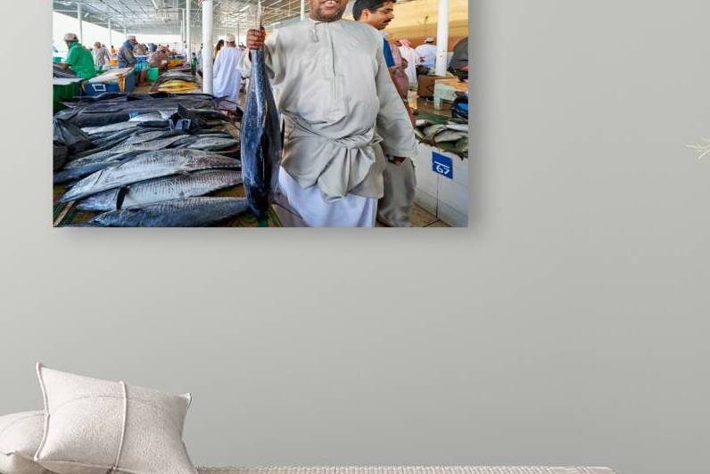 Fish seller showing fresh catch at muscat oman fish market by Marco Brivio