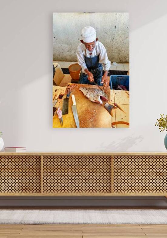 Local fisherman prepares fish at Muscat Oman fish market by Marco Brivio
