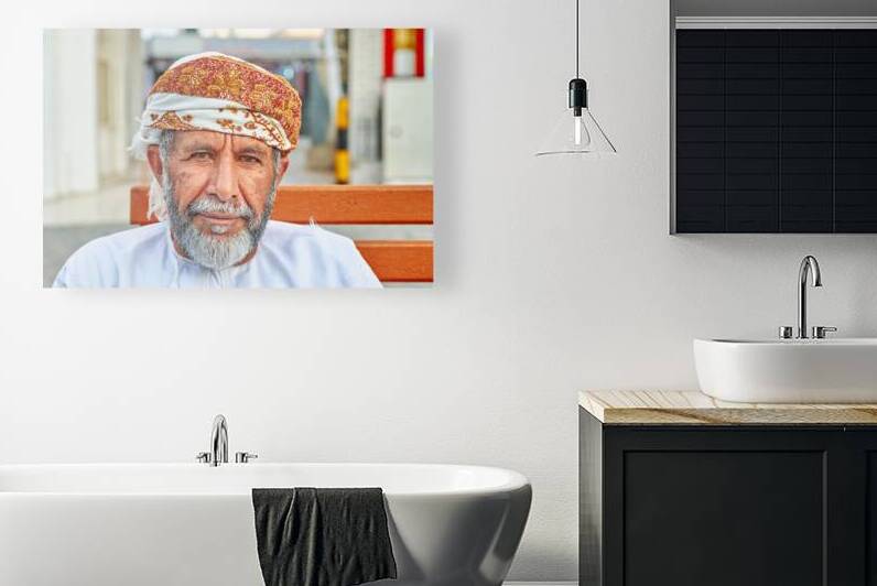 Man sitting on a bench in Muscat Oman during the day by Marco Brivio