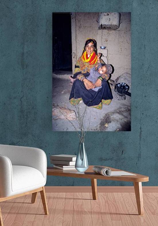 A woman holds her child in a Kalash village by Marco Brivio