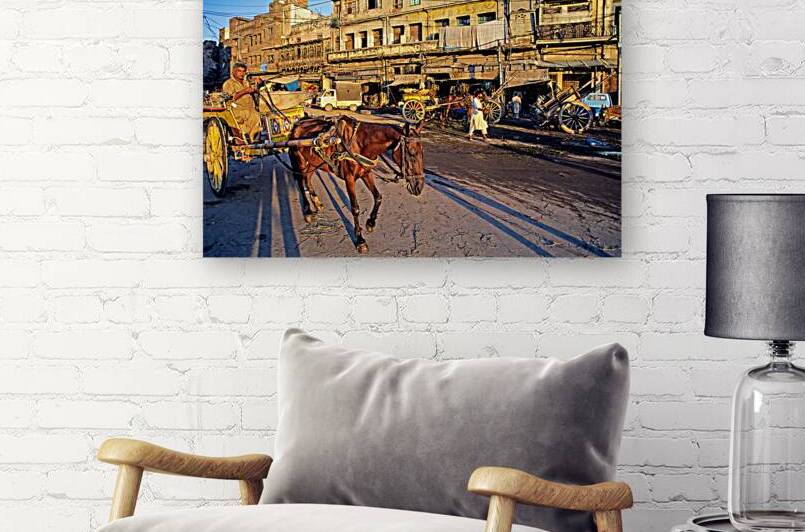 Horses and carts on the busy streets of Lahore at dusk by Marco Brivio