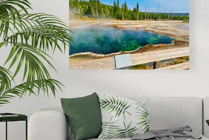 Tourists can see the deep blue Abyss Pool in Yellowstone National Park with steam rising from the hot springs during the warm afternoon. by Marco Brivio