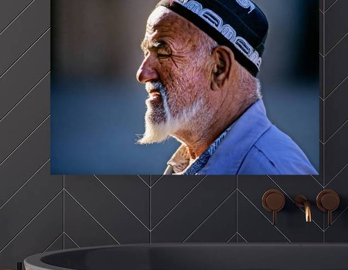 Elderly man in traditional clothing walks in Khiva Uzbekistan by Marco Brivio