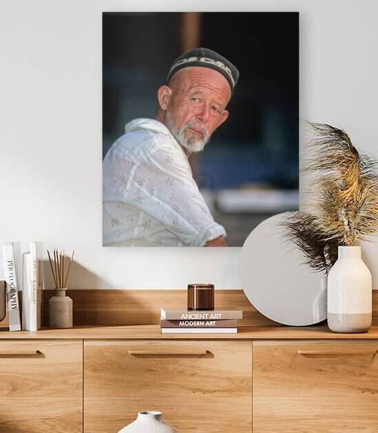 Man in traditional attire sitting in Bukhara Uzbekistan by Marco Brivio