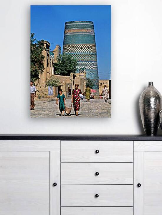 Women and children walk by the tall tower in Khiva Uzbekistan by Marco Brivio