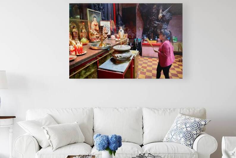 Woman praying at temple in Ho Chi Minh City in Vietnam by Marco Brivio