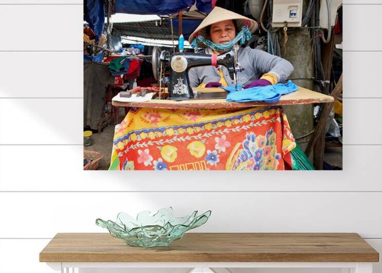 Woman sewing at a market in Phu Quoc Vietnam during the day by Marco Brivio