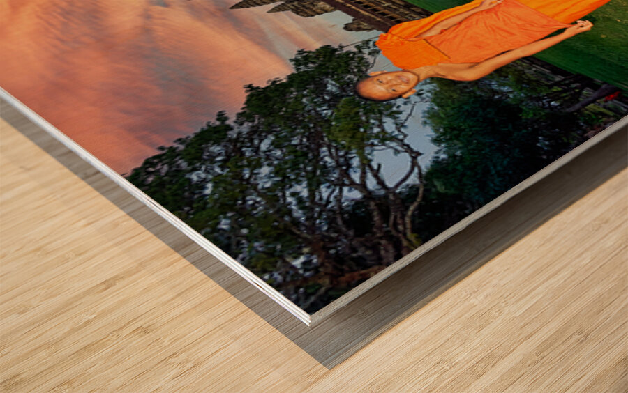Monk stands by pond with Angkor Wat and sunset sky. Wood print