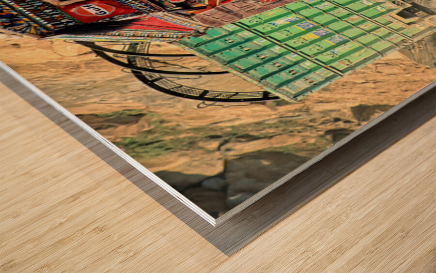 Trucks travel toward Shandur Pass in Pakistans rugged terrain Wood print